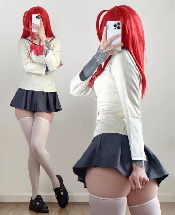 Woman with vibrant red hair in a school uniform cosplay with white thigh-high stockings